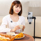 Woman enjoying coffee while using smartphone on tripod with wireless lavalier microphone.