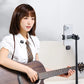 Woman playing guitar with smartphone on tripod and wireless lavalier microphone.