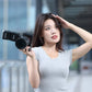 Woman showcasing Ulanzi F32 flash on camera, standing in a bright environment.