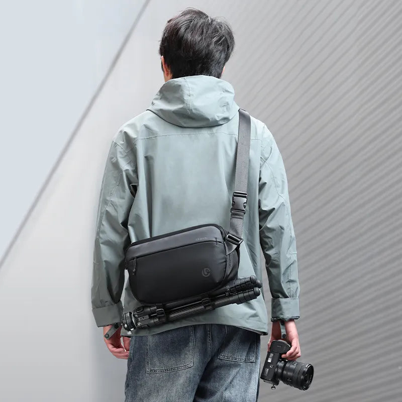 Man carrying Ulanzi 10L camera sling bag with tripod and camera outdoors.